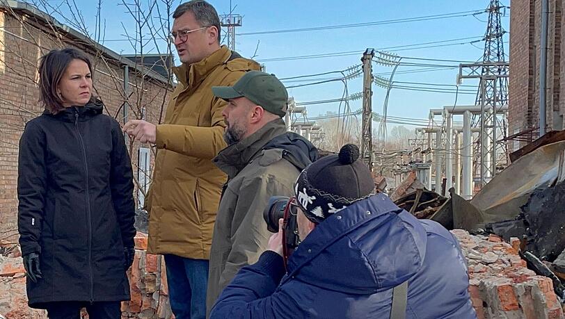 Annalena Baerbock im Gespräch mit dem ukrainischen Außenminister Dmytro Kuleba (3.v.r) in Charkiw auf dem Gelände eines den Russen zerstörten Umspannwerkes.