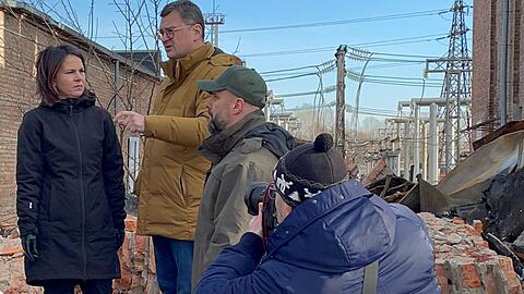 Annalena Baerbock im Gespräch mit dem ukrainischen Außenminister Dmytro Kuleba (3.v.r) in Charkiw auf dem Gelände eines den Russen zerstörten Umspannwerkes.