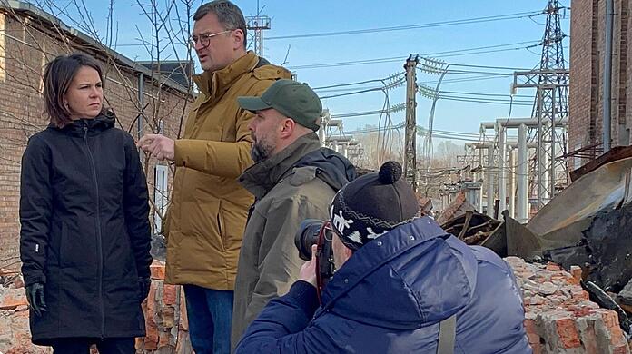 Annalena Baerbock im Gespräch mit dem ukrainischen Außenminister Dmytro Kuleba (3.v.r) in Charkiw auf dem Gelände eines den Russen zerstörten Umspannwerkes.