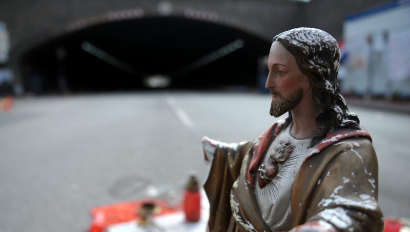 Verwelkte Blumen und eine Jesusstatue weisen den Unglucksort aus. Verwelkte Blumen und eine Jesusstatue weisen den Unglucksort aus.