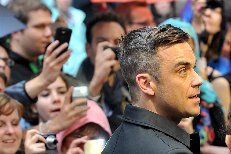 Weltstar im Fan-Gewusel: Robbie Williams verteilte Autogramme vor dem Mathäser-Kino.