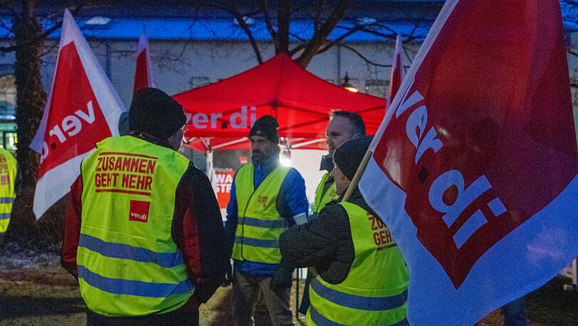 Streikende halten Fahnen der Gewerkschaft Verdi und sind mit Warnwesten gekleidet. Streikende halten Fahnen der Gewerkschaft Verdi und sind mit Warnwesten gekleidet.