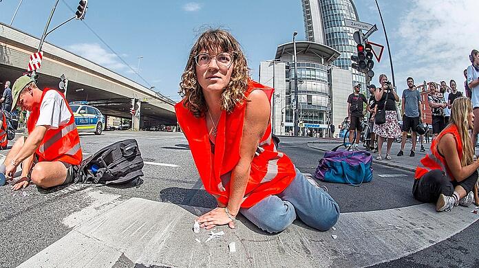 Aktivisten blockieren bei einer Aktion in der Münchner Innenstadt die Trappentreustaße. Künftig wollen sie den Verkehr nicht mehr behindern.
