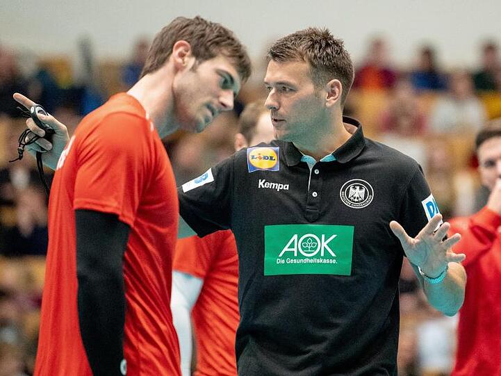 DHB-Kapitän Uwe Gensheimer (l) lauscht den Ausführungen von Bundestrainer Prokop (M).