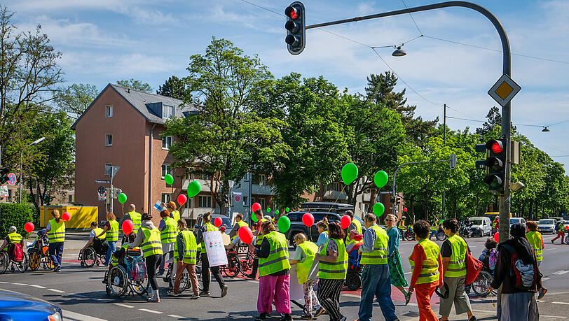 Mit Trillerpfeifen und Trommeln machen die Betroffenen auf sich aufmerksam, w&auml;hrend sie wieder und wieder die Stra&szlig;e &uuml;berqueren.