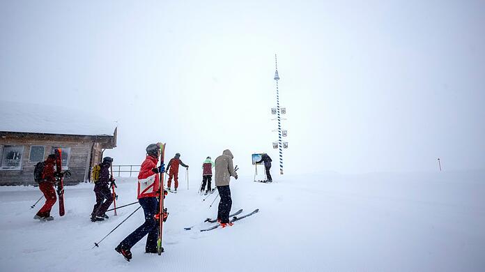 Skifahrer trotzen zum Saisonstart dichtem Nebel und Schneefall auf der Zugspitze.