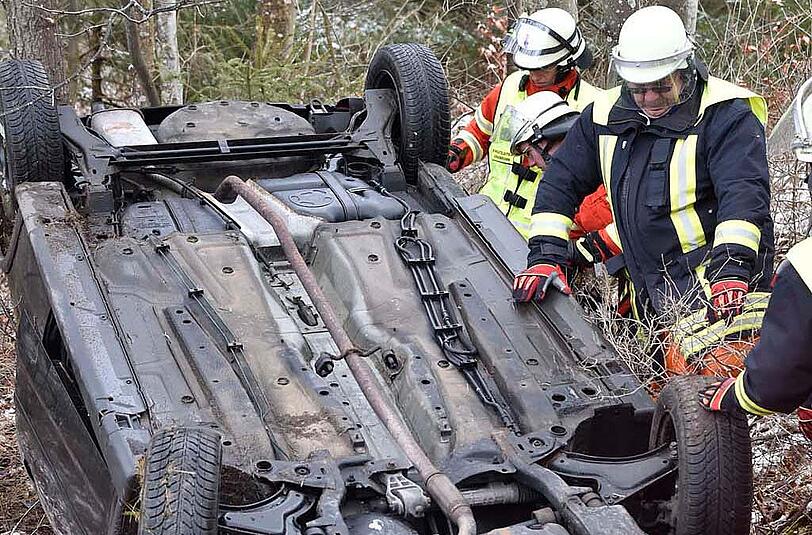 Die Einsatzkräfte aus Grasbrunn und Harthausen stellen das Autowrack wieder auf die Räder.