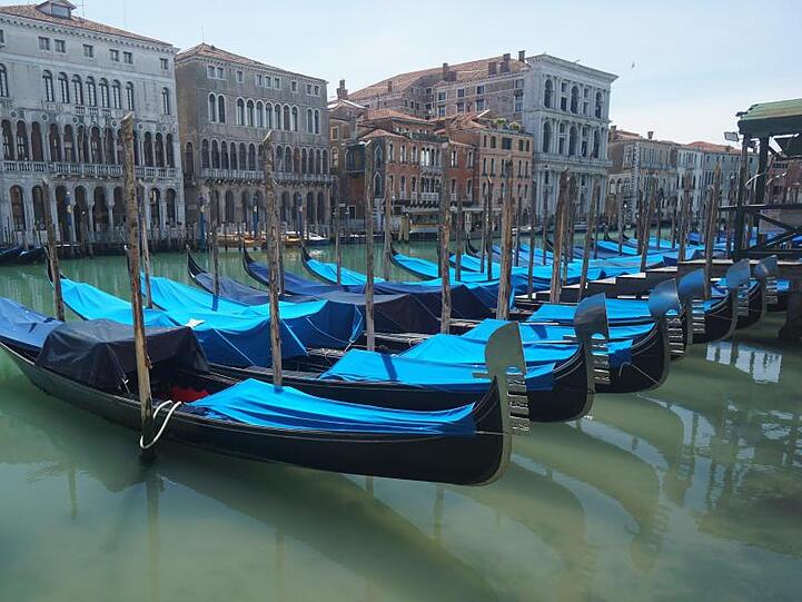 Gondeln sind auf dem Canal Grande an Holzpfählen festgemacht.