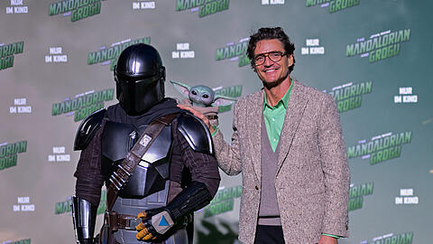 Pedro Pascal (r.) steht w&auml;hrend eines Fan-Events f&uuml;r den Disney-Film "Star Wars: The Mandalorian and Grogu" neben einem Cosplayer im Outfit seiner Rolle des Din Djarin (Spitzname: "Mando").