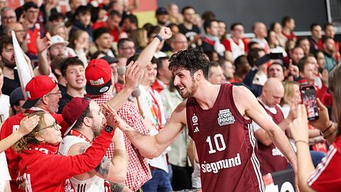 Der Münchener Leandro Bolmaro klatscht sich nach dem Sieg im Pokal-Halbfinale gegen die Bamberg Baskets mit den Fans ab.