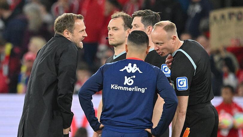 Mainz-Coach Bo Svensson (l) diskutiert mit Schiedsrichter Matthias Jöllenbeck (verdeckt).