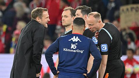 Mainz-Coach Bo Svensson (l) diskutiert mit Schiedsrichter Matthias Jöllenbeck (verdeckt).