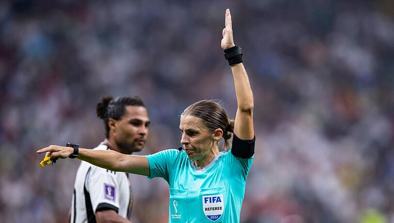 Schiedsrichterin Stephanie Frappart gestikuliert. Im Hintergrund steht Deutschlands Serge Gnabry (l).