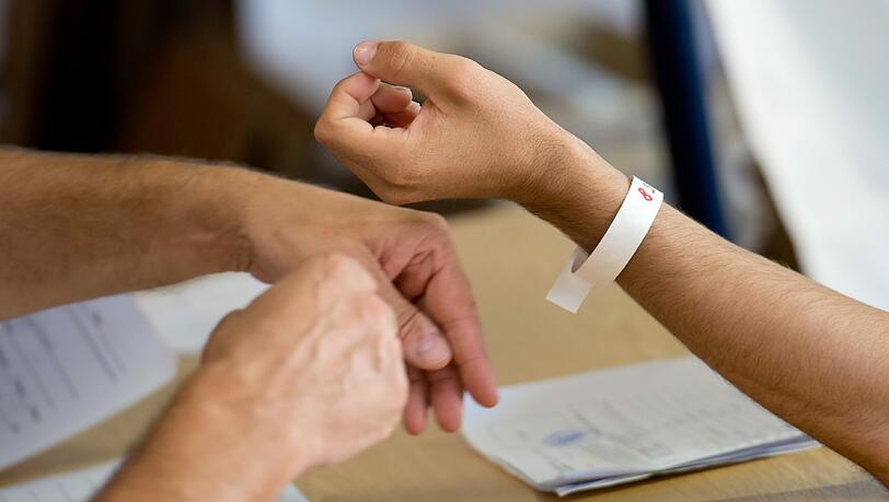 Ein Flüchtling bekommt in einer Registrierungsstelle für Flüchtlinge von einem Bundespolizisten ein Armband mit einer Nummer. Um der Flüchtlingswelle Herr zu werden, bekommt Bayern vom Bund 100 zusätzliche Bundespolizisten gestellt. Ein Flüchtling bekommt in einer Registrierungsstelle für Flüchtlinge von einem Bundespolizisten ein Armband mit einer Nummer. Um der Flüchtlingswelle Herr zu werden, bekommt Bayern vom Bund 100 zusätzliche Bundespolizisten gestellt.