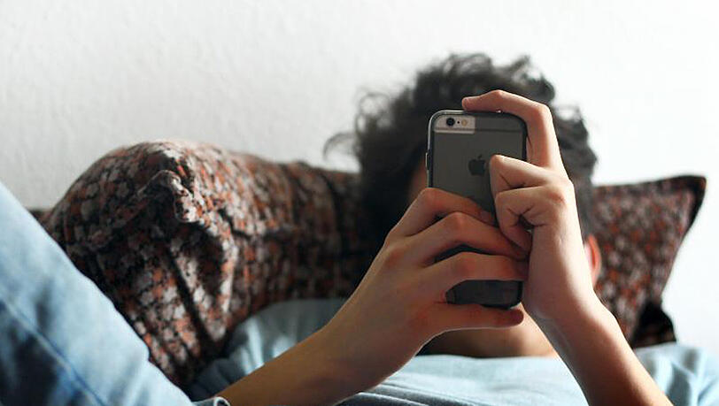 Ein 17-jähriger beschäftigt sich mit seinem Smartphone. Ein 17-jähriger beschäftigt sich mit seinem Smartphone.