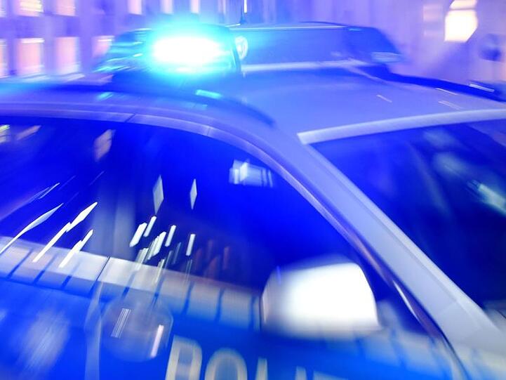 Ein Streifenwagen der Polizei steht mit eingeschaltetem Blaulicht auf der Straße.
