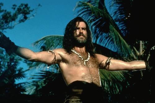 Der Schauspieler Pierce Brosnan als Schiffbrüchiger im Film "Robinson Crusoe".