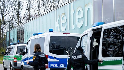 Einsatzkräfte der Bereitschaftspolizei steigen vor dem Kelten Römer Museum aus ihren Fahrzeugen aus.