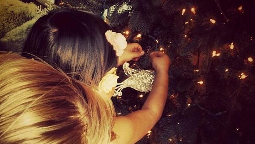 Mama Katherine und Tochter Naleigh schmücken den Weihnachtsbaum Mama Katherine und Tochter Naleigh schmücken den Weihnachtsbaum