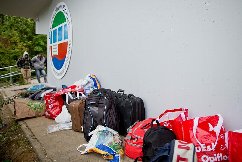 Mehrere Taschen von Flüchtlingen stehen vor einer Schulsporthalle in Margetshöchheim, die als Notunterkunft dient. Fast ein Dutzend Flüchtlinge hatten in der Nacht zu Dienstag vor der Halle mit einem nächtlichen Sitzstreik für eine schnellere Bearbeitung ihrer Asylanträge protestiert.