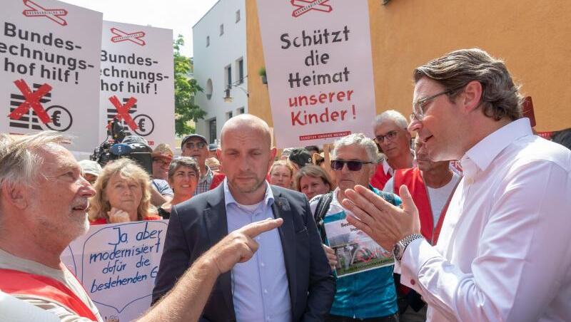 Bundesverkehrsminister Andreas Scheuer (CSU) unterhält sich mit demonstrierenden Anwohnern der Region Rosenheim. Foto: Peter Kneffel Bundesverkehrsminister Andreas Scheuer (CSU) unterhält sich mit demonstrierenden Anwohnern der Region Rosenheim. Foto: Peter Kneffel