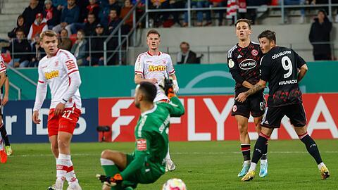 Dem Regensburger Torhüter Dejan Stojanovic (M) gleitet der Ball durch die Beine zum 0:3.