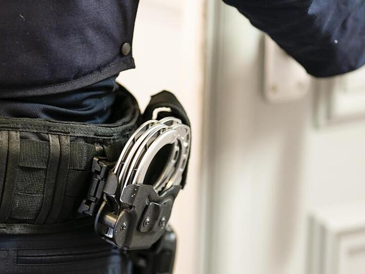 Handschellen sind an einem Gürtel eines Justizvollzugsbeamten befestigt. Foto: Frank Molter/dpa/Symbolbild