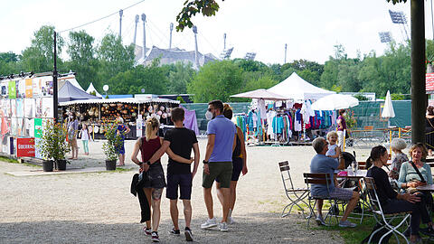 Entspannte Atmosphäre, kein Trubel und im Hintergrund das Olympiastadion: Auf dem Tollwood ließen sich's Alt und Jung gut gehen.