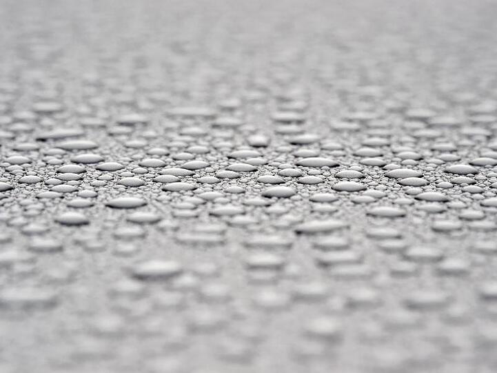 Nach einem Regenschauer perlen Wassertropfen auf einem Auto. Foto: Patrick Pleul/dpa-Zentralbild/dpa/Archivbild