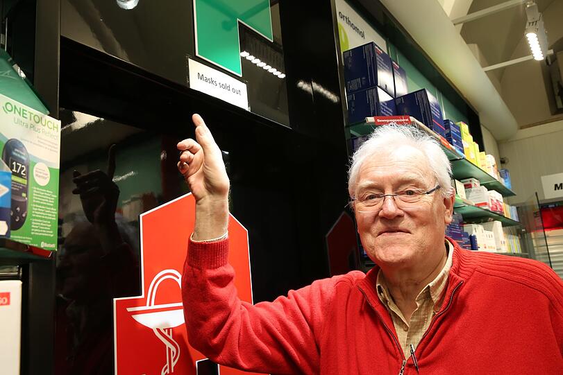 Josef Grimm, Chef der Rathausapotheke, zeigt auf das Schild "Sold out".