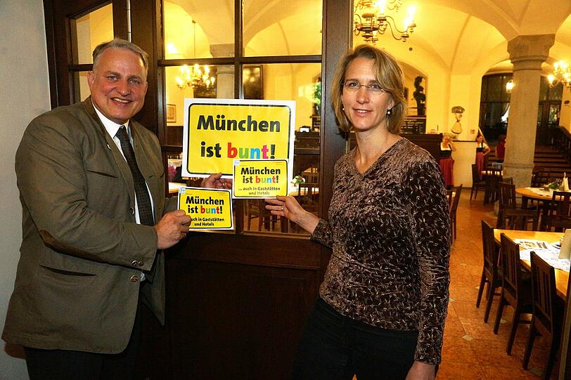 "München ist bunt, auch in den Gaststätten" &ndash; diese Kampagnen-Aufkleber sollen möglichst alle Münchner Wirte an ihren Gaststätten anbringen. Dafür werben Wiesnwirt Christian Schottenhamel und Miriam Heigl von der Fachstelle gegen Rechts.