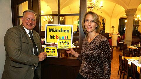 "München ist bunt, auch in den Gaststätten" &ndash; diese Kampagnen-Aufkleber sollen möglichst alle Münchner Wirte an ihren Gaststätten anbringen. Dafür werben Wiesnwirt Christian Schottenhamel und Miriam Heigl von der Fachstelle gegen Rechts.