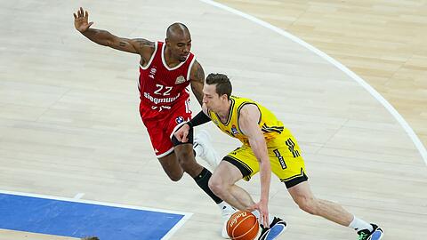 Bayerns Isiaha Mike (links) und Justin Bean von Alba Berlin k&auml;mpfen um den Ball.