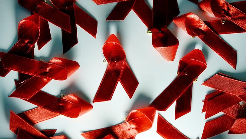 Rote Aids Schleifen liegen auf einem Tisch.
