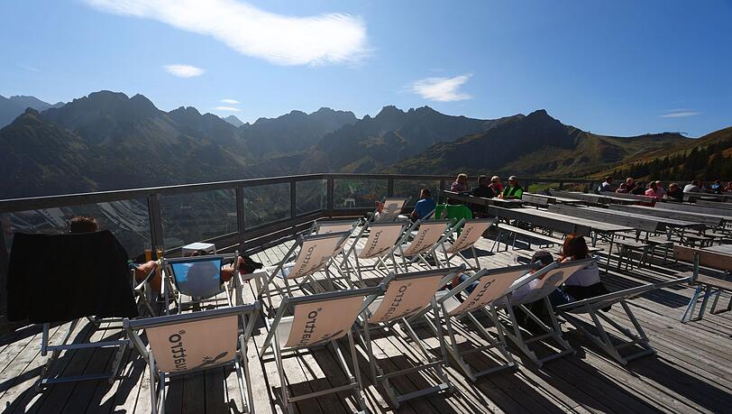 Ausflügler genießen an der Mittelstation der Fellhornbahn auf der Sonnenterrasse den Sonnenschein.