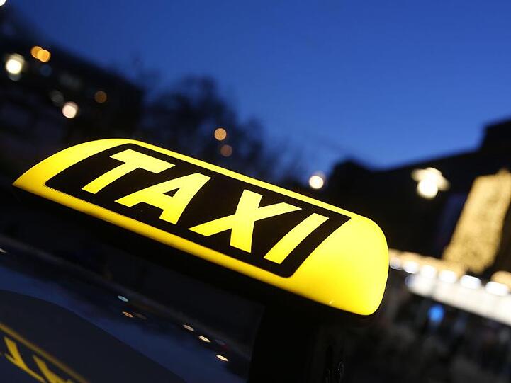 Schild leuchtet auf einem Taxi. Foto: David Young/Archiv