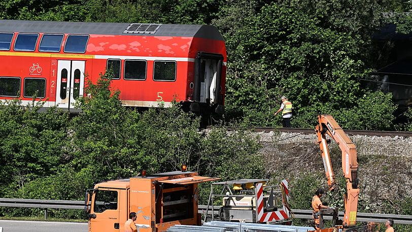 Arbeiter bereiten die Bundesstraße B2 neben der Zugunglücksstelle wieder für den Verkehr vor.