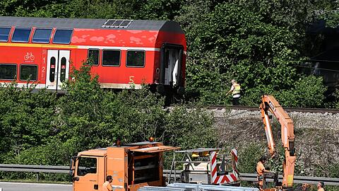 Arbeiter bereiten die Bundesstraße B2 neben der Zugunglücksstelle wieder für den Verkehr vor.