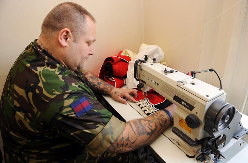 Ein Sergeant erledigt kleine Änderungen an seiner Uniform selbst.