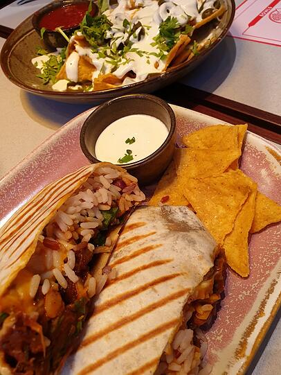 Der Burrito und hinten die Nachos mit viel Soße.