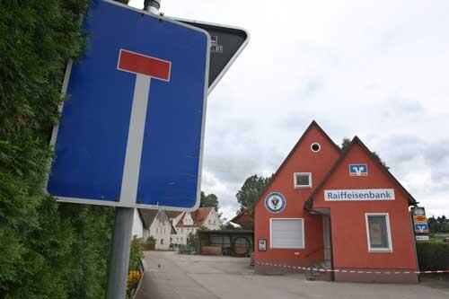 Eine Polizeiabsperrung hängt am Montag (16.08.2010) vor einer Filiale der Raiffeisenbank von Unterknöringen (Schwaben). Die Bank wurde am Nachmittag von einem Mann überfallen.