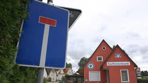 Eine Polizeiabsperrung hängt am Montag (16.08.2010) vor einer Filiale der Raiffeisenbank von Unterknöringen (Schwaben). Die Bank wurde am Nachmittag von einem Mann überfallen. Eine Polizeiabsperrung hängt am Montag (16.08.2010) vor einer Filiale der Raiffeisenbank von Unterknöringen (Schwaben). Die Bank wurde am Nachmittag von einem Mann überfallen.