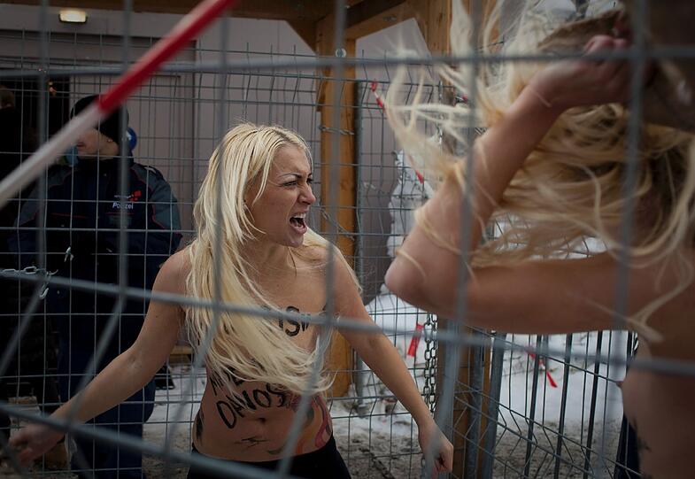 Nacktprotest in Davos: Ukrainerinnen demonstrieren barbusig am Zaun vor dem Weltwirtschaftsforum. Die Polizei greift ein - die Bilder.