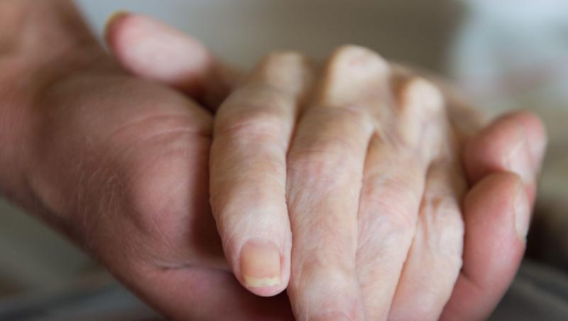 Ein Besucher hält die Hand einer Frau in einem Altenheim. Foto: Sebastian Kahnert/zb/dpa/Symbolbild Ein Besucher hält die Hand einer Frau in einem Altenheim. Foto: Sebastian Kahnert/zb/dpa/Symbolbild