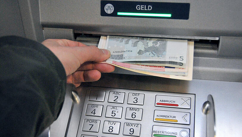 Eine Hand entnimmt dem Geldschlitz eines Bankautomaten die gewünschten Banknoten. Geldautomaten in Deutschland werden immer häufiger manipuliert. Eine Hand entnimmt dem Geldschlitz eines Bankautomaten die gewünschten Banknoten. Geldautomaten in Deutschland werden immer häufiger manipuliert.