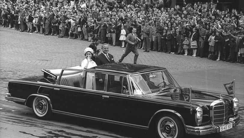 Elizabeth mit Alfons Goppel im offenen Mercedes in der Arnulfstraße. Elizabeth mit Alfons Goppel im offenen Mercedes in der Arnulfstraße.