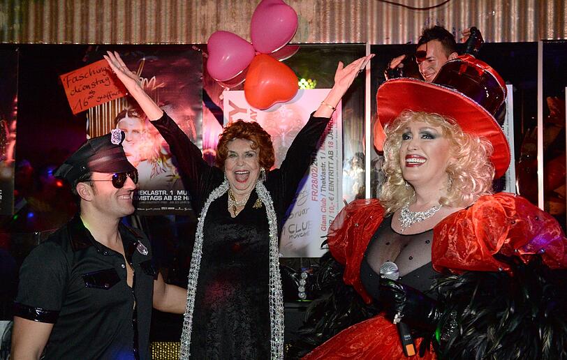 Die Gastgeberin Gloira Gray (r) und die neunzigjährige Ausnahmekünstlerin Ruth Megary (M) stehen im Glam Club auf der Bühne.