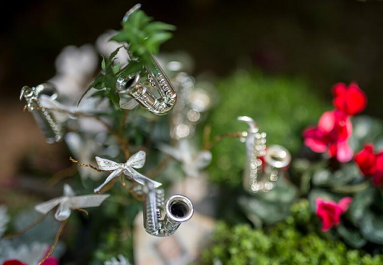 Kleine Saxofone sind nach der Beisetzung auf einem Blumengesteck für den verstorbenen Musiker Max Greger auf dem Waldfriedhof in Grünwald zu sehen