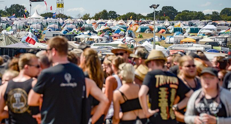 Festivalbesucher laufen in der gleißenden Sonnen über die sich langsam füllenden Zeltplätze. Die traditionelle Schlammschlacht ist bislang ausgeblieben, es droht eine Hitzeschlacht.