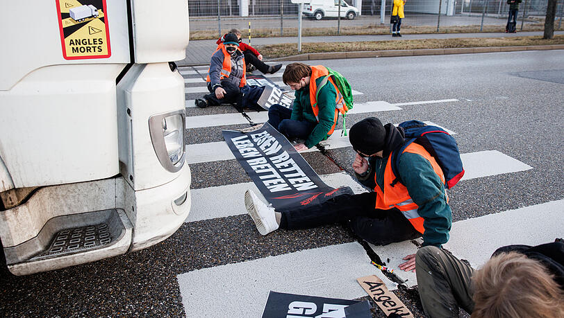 Aktivisten der Gruppe "Die letzte Generation" haben sich mit ihren Händen auf einen Zebrastreifen auf der Südallee, einer Zufahrt zum Frachtbereich vom Münchner Flughafen, geklebt. Aktivisten der Gruppe "Die letzte Generation" haben sich mit ihren Händen auf einen Zebrastreifen auf der Südallee, einer Zufahrt zum Frachtbereich vom Münchner Flughafen, geklebt.